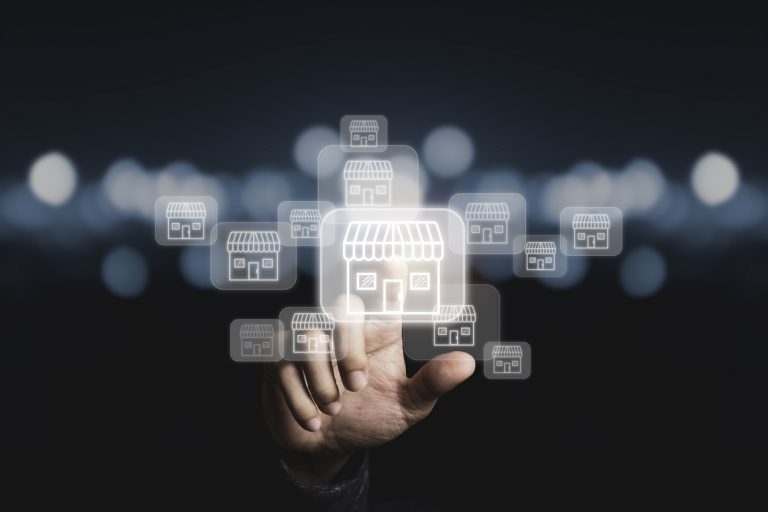 Businessman hand pointing to virtual shopping store which connection line with others small shopping stores , expand and development franchise concept